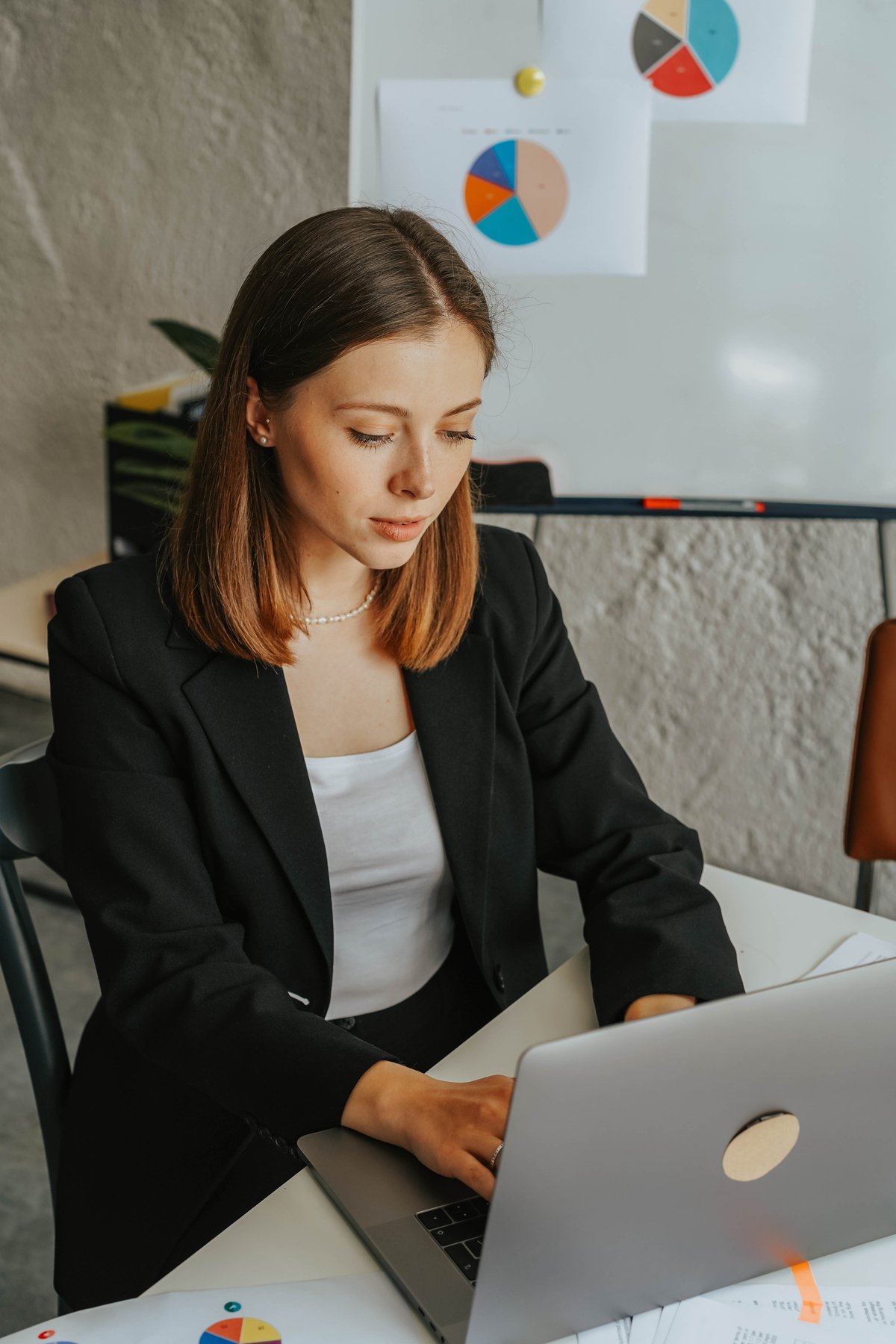 Woman in Black Blazer Using a Laptop